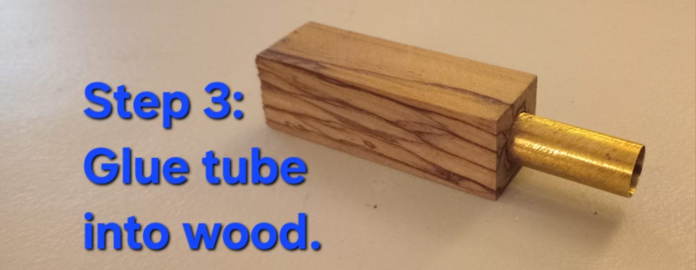 Glue the tube — brass tube being inserted and epoxied into the drilled wood blank