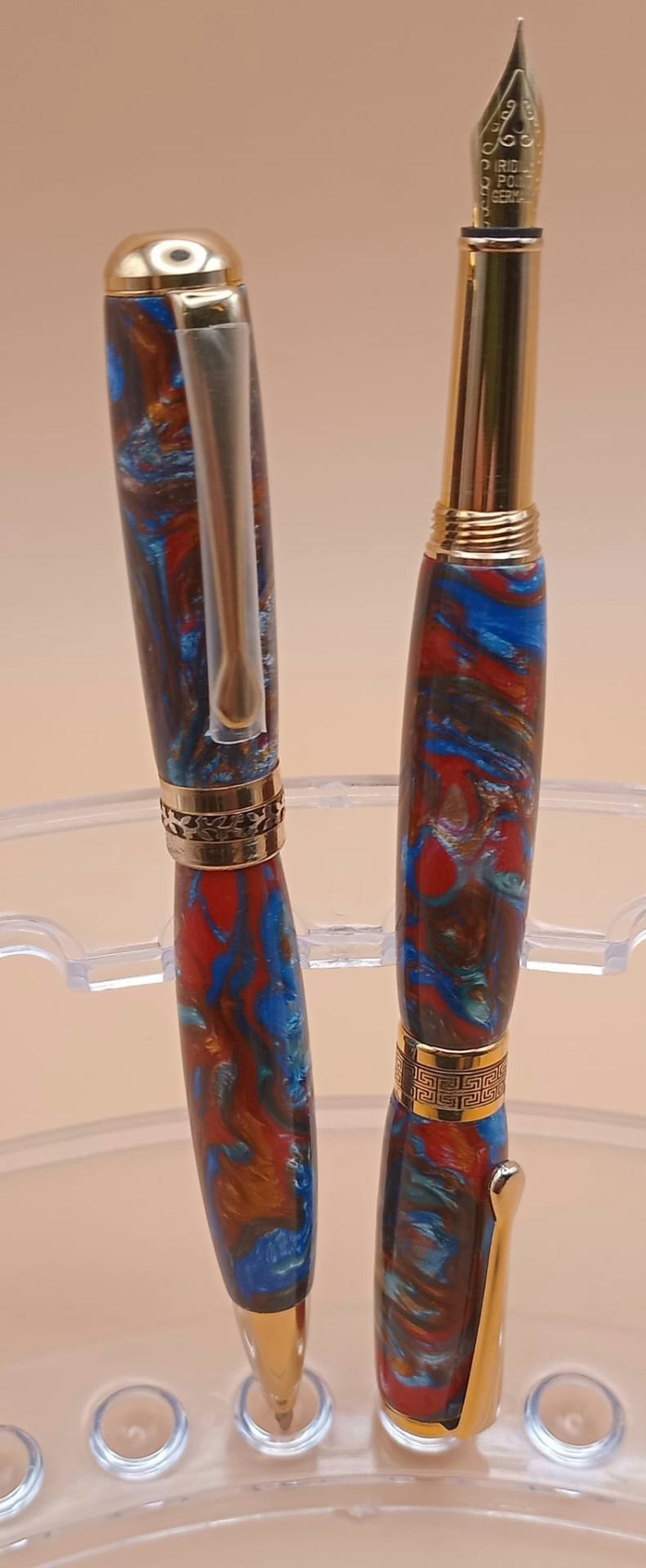 Handcrafted red and blue swirl resin fountain pen and matching rollerball with gold hardware
