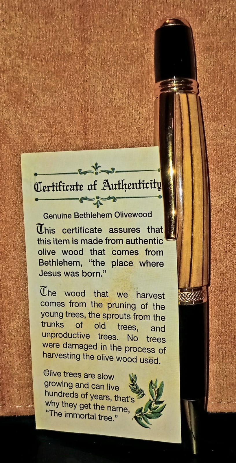Handcrafted Bethlehem olivewood rollerball pen with rose-gold hardware, shown with its Certificate of Authenticity card